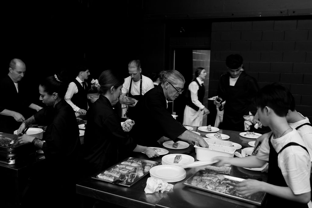 Hospitality team plating dishes together during service