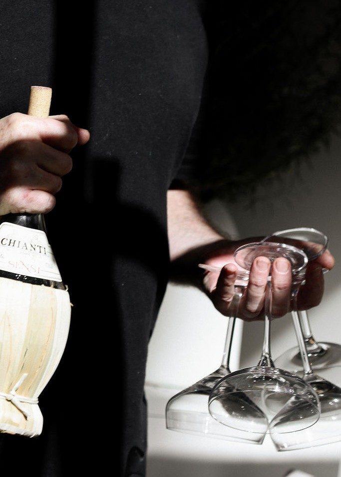 Guests clinking white wine glasses over a table of shared plates