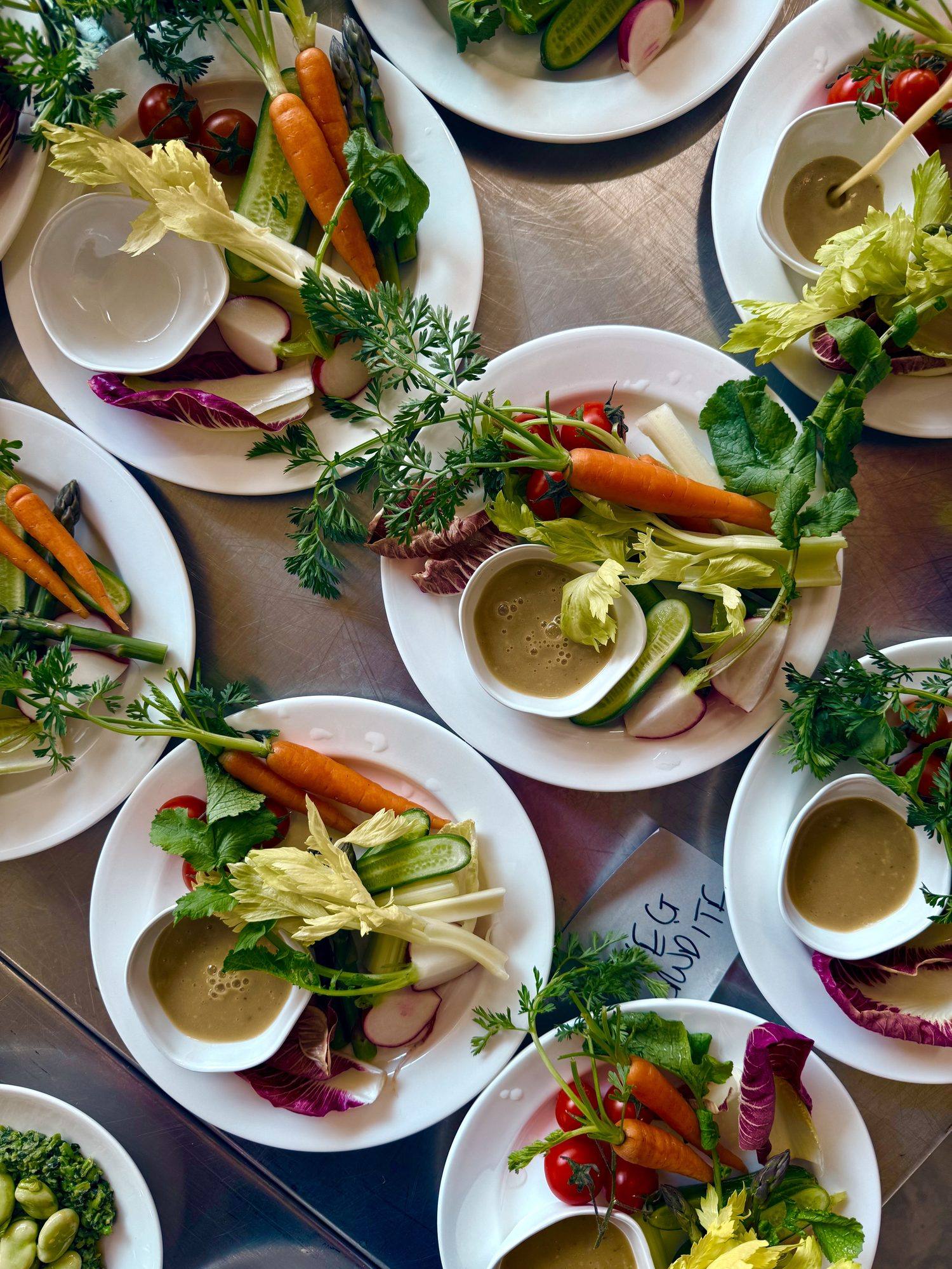 Overhead view of crudité plates with carrots, radish, celery and dipping sauce