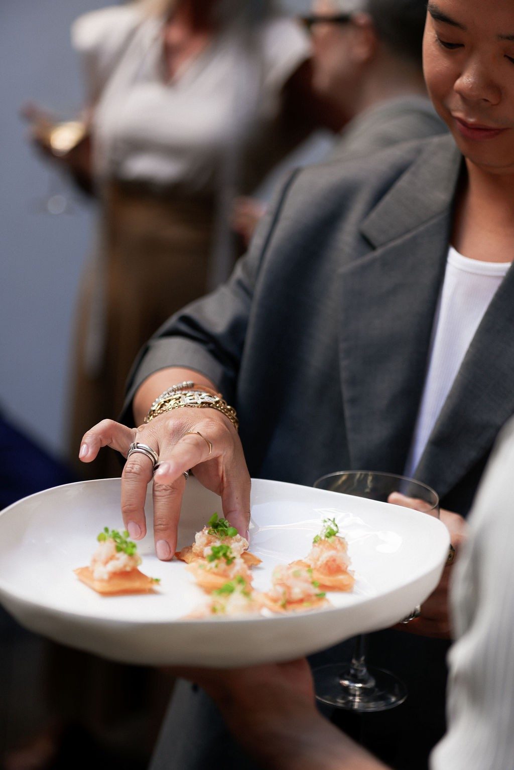 Hand placing a delicate canapé on a white plate